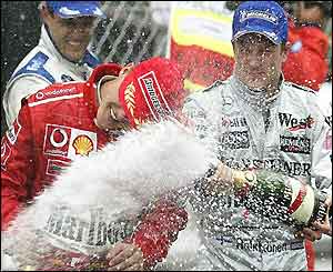 Kimi Raikkonen sprays champagne at Michael Schumacher on the podium