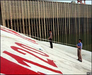 Workers check the level markers as the sluice gates close