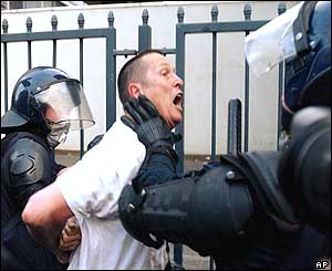 Demonstrator led away following heavy riots on Saturday and Sunday night