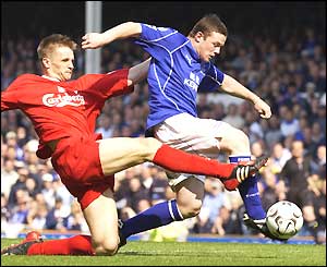 Wayne Rooney muscles his way past Liverpool's Igor Biscan