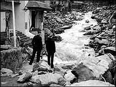 Water pouring down High Street with boulders strewn on either side