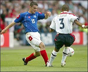 Slobodan Markovic is closed down by England's Ashley Cole