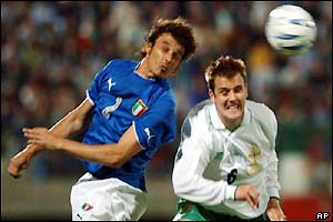 Italy's Massimo Oddo (left) jumps for a header with Northern Ireland's Danny Griffin 