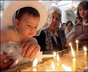 Baby lighting candle in Damascus church