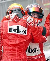 Scumacher and Barrichello embrace at the end of the race