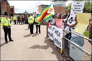 Protesters outside the ground make wave banners against Zimbabwe president Robert Mugabe's regime