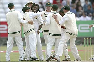 Doug Hondo (centre) is congratulated by his Zimbabwe team-mates after taking another wicket
