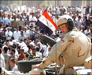 A US soldier atop a tank stands guard as protesters voice their opposition to the talks 