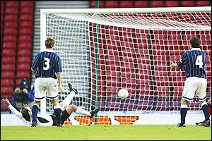 Roland Kirchler lies on his back after stabbing the ball in to score for Austria