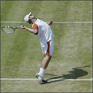 Roddick tosses the ball high before serving to Agassi