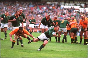South Africa's Joel Stransky evades a last-ditch tackle to score the winning try against Australia in the first match of the tournament
