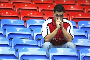 An Arsenal fan sits dejected after the 2-2 draw at Bolton