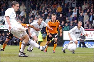 Players and fans alike watch James Thomas as he strikes the ball from the penalty spot..
