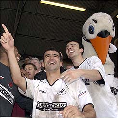 Roberto Martinez and Leon Britton celebrate with club mascot Cyril the Swan