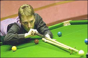 Doherty uses a rest to reach across the table