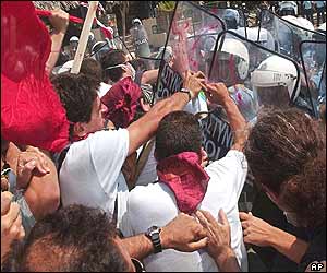 Members of Greek Communist Party hit riot police officers' riot shields