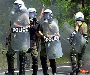 Police with riot shields march on protesters 