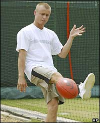 Lleyton Hewitt relaxes with a Aussie Rules football
