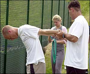 Lleyton Hewitt stretches during practice