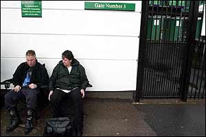 Tennis fans queue in the rain