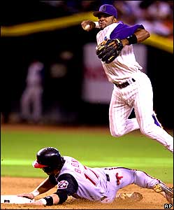Arizona Diamondbacks shortstop Tony Womack leaps over the slide by Cincinnati Reds runner Aaron Boone to turn a double play in the eighth innings 
