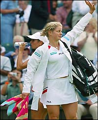 Kim Clijsters waves to the crowd after her first-round win