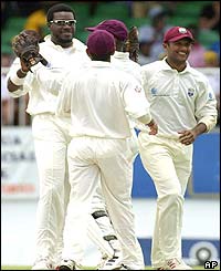 Chris Gayle of the West Indies is congratulated by wicket keeper Ridley Jacobs after claiming the wicket of Justin Langer