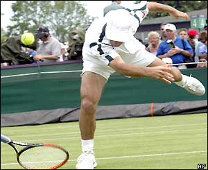 Fabrice Santoro drops his racquet while stretching for a shot