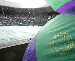 The rain comes down on umbrellas on Centre Court at Wimbledon