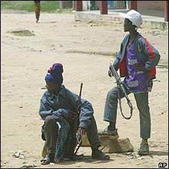 Child soldiers armed with AK-47s stand near the UN compound 