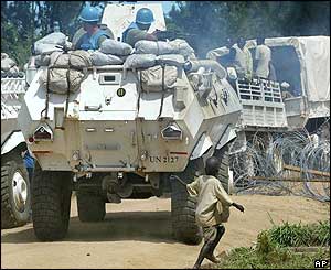 A boy runs alongside a UN armoured vehicle escorting a convoy out of town