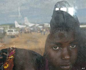 A boy watches through a window at the planes at Bunia airport