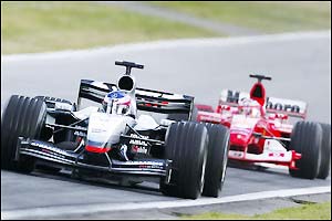 McLaren's Kimi Raikkonen battles with Ferrari's Rubens Barichello for second