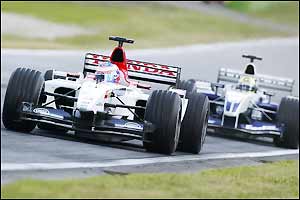 Britain's Jenson Button holds off Ralf Schumacher
