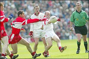 Tyrone skipper Peter Canavan gets the ball away from Sean Marty Lockhart