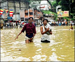 People try to salvage their belongings on a flooded road Ratnapura: Courtesy Sriyantha Walpola