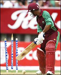 Carlton Baugh watches a ball from Glenn McGrath send his middle stump spinning