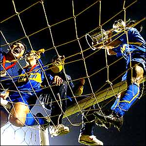 Hugo Ibarra climbs into the goal to celebrate with the Copa Libertadores