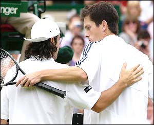 Sebastien Grosjean and Tim Henman slap each other on the back as Henman losese