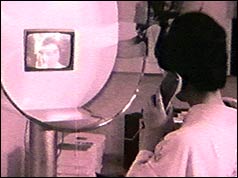 Caller at public phone booth with screen showing person being called