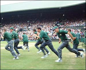 Wimbledon's covers team charge onto Centre Court as rain delays play