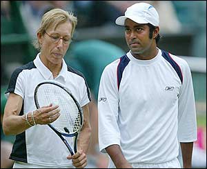Navratilova and doubles partner Leander Paes chat during a match