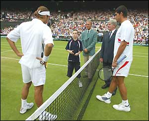 Roger Federer and Mark Philippoussis stand either side of the net for the toss