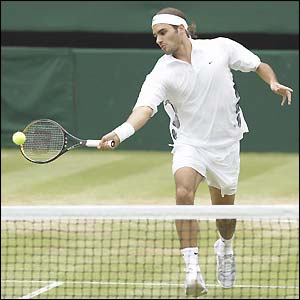 Roger Federer plays a forehand volley at the net