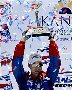 Brian Herta celebrates with the trophy after winning the Kansas Indy 300