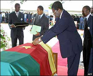 Cameroon' Prime Minister Peter Masany Musonge lays a posthumous medal on Foe's coffin