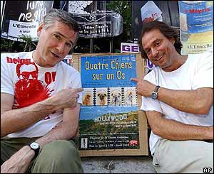 American author John Patrick Shanley and producer John Pepper point to a poster of Shanley's play Four Dogs on a Bone