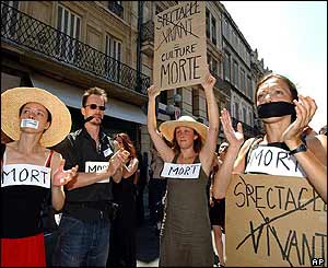 Striking performers, gagged and wearing placards reading 
