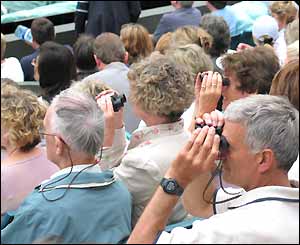 The crowd look through bionoculars