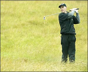 Philip Price plays out of the rough on the first